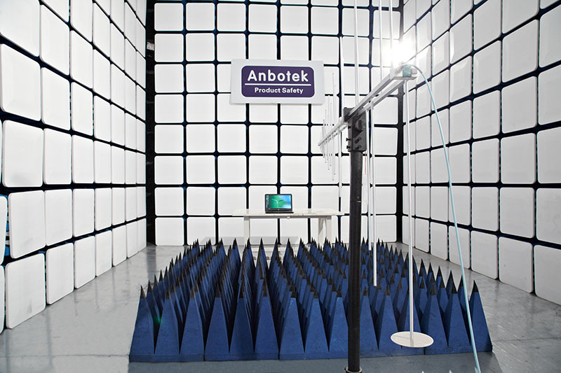 Anbotek EMC anechoic chamber with blue absorber cones, antenna mast and test table