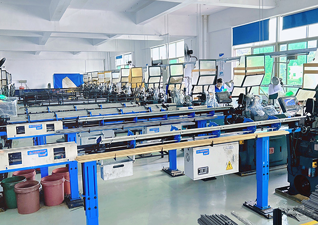 Rows of automatic lathes with bar feeders in Honscn's workshop