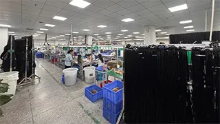 Harness assembly workshop with workbenches and blue parts bins