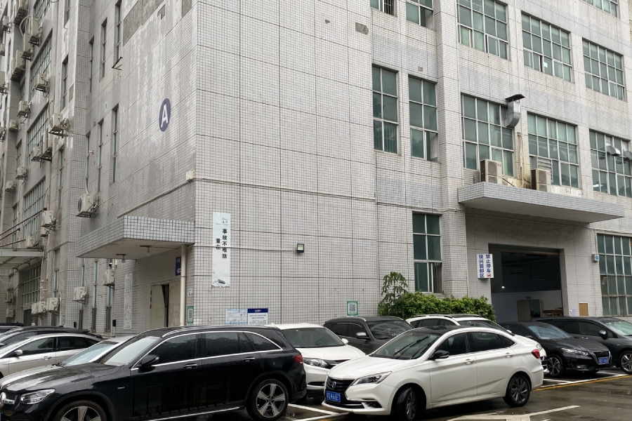 前方停有车辆的多层工业厂房