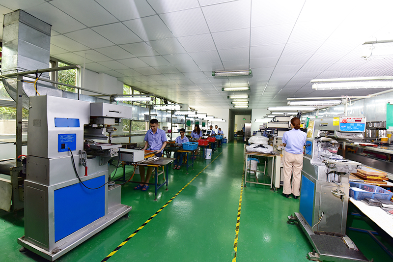Long green-floored workshop at Siking with pad-printing machines and workbenches