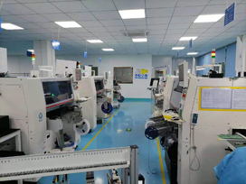 SMT line of placement machines on a blue-floored workshop