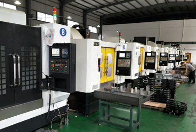 Row of numbered CNC machining centres used for post-machining castings, with trays of parts in front