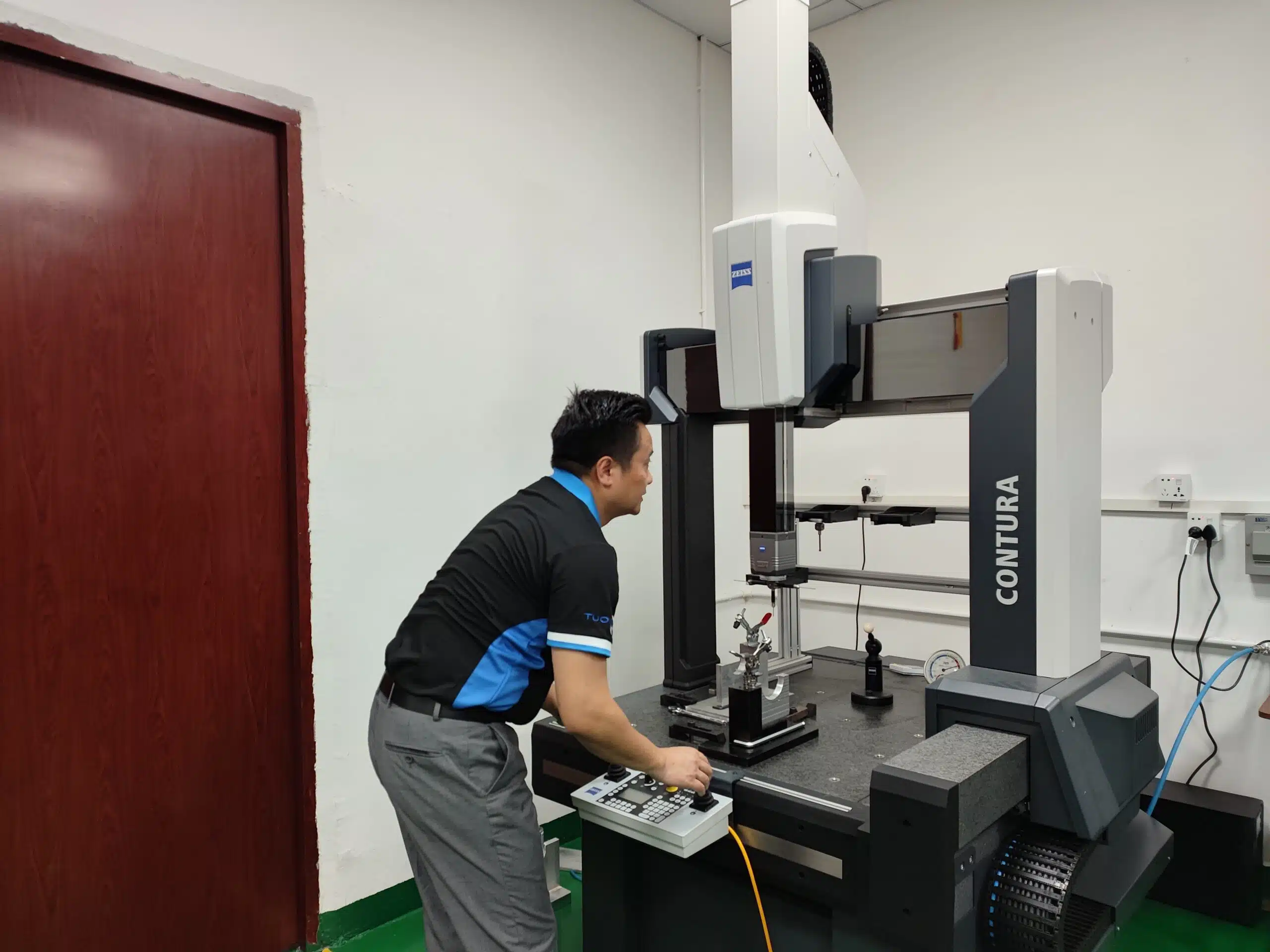 Technician operating a CNC machine at Tuowei's workshop