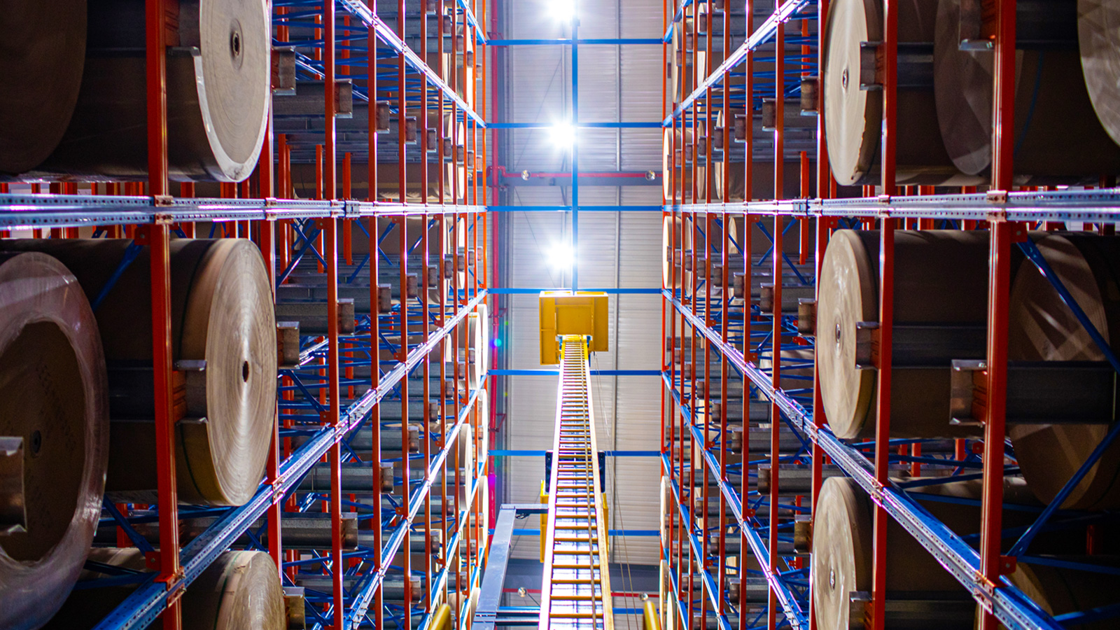 Automated high-bay storage racks holding large paper rolls in a Voion warehouse