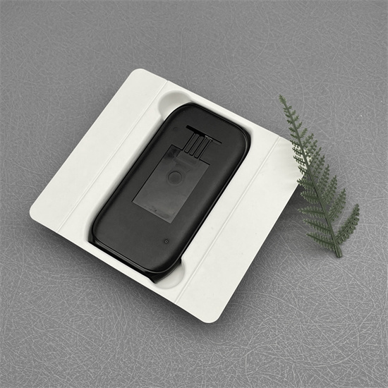White molded pulp tray holding a black handheld device